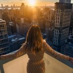 woman witnessing a sunset atop a tall building