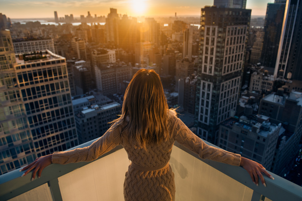 woman witnessing a sunset atop a tall building