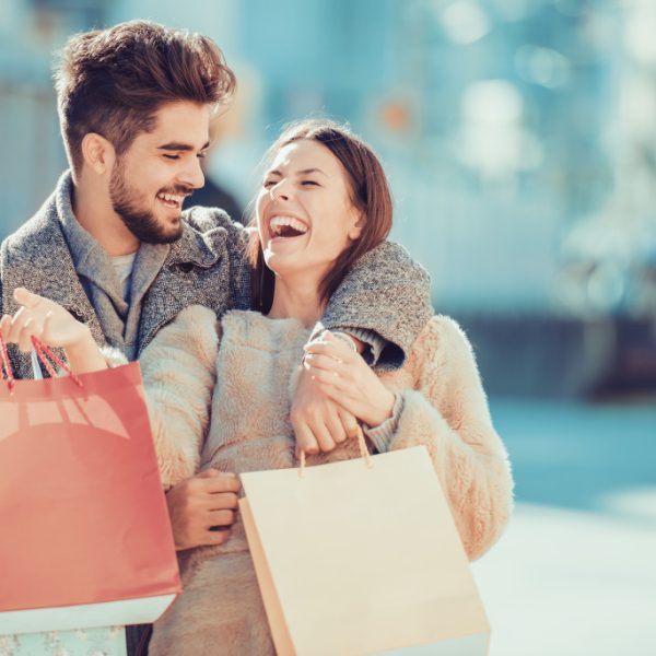 couple embracing while holding their shopping bags
