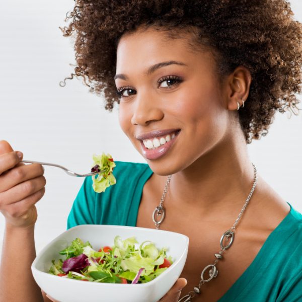 Close-up Of Beautiful African American Woman Eating Salad At Home