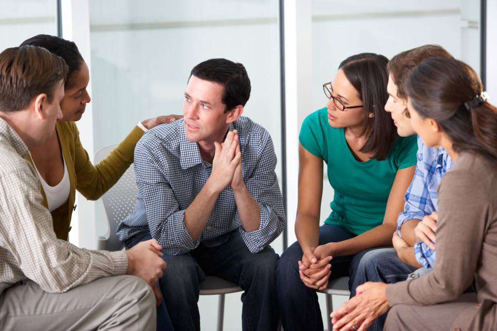 a person talking while others around are listening