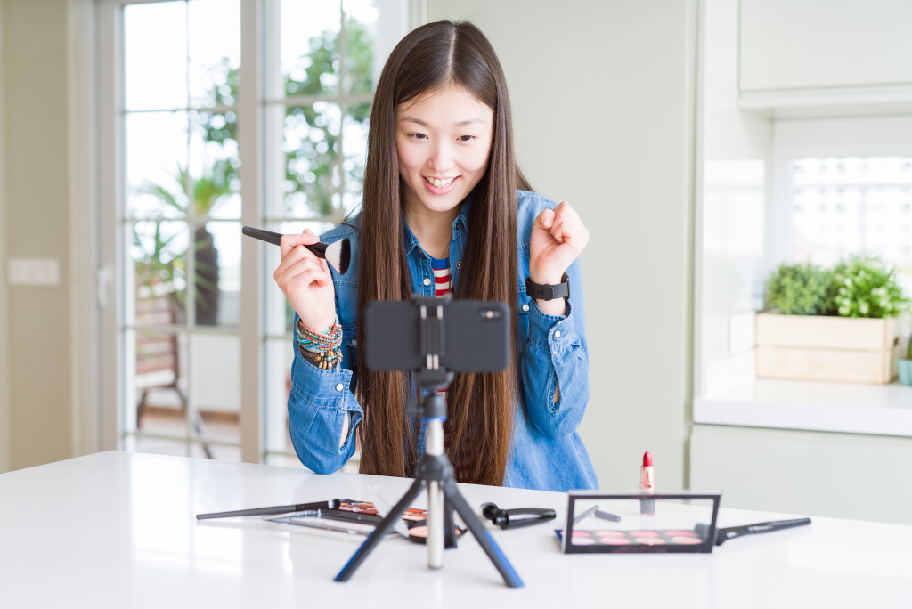 a female influencer in front of a phone making a video