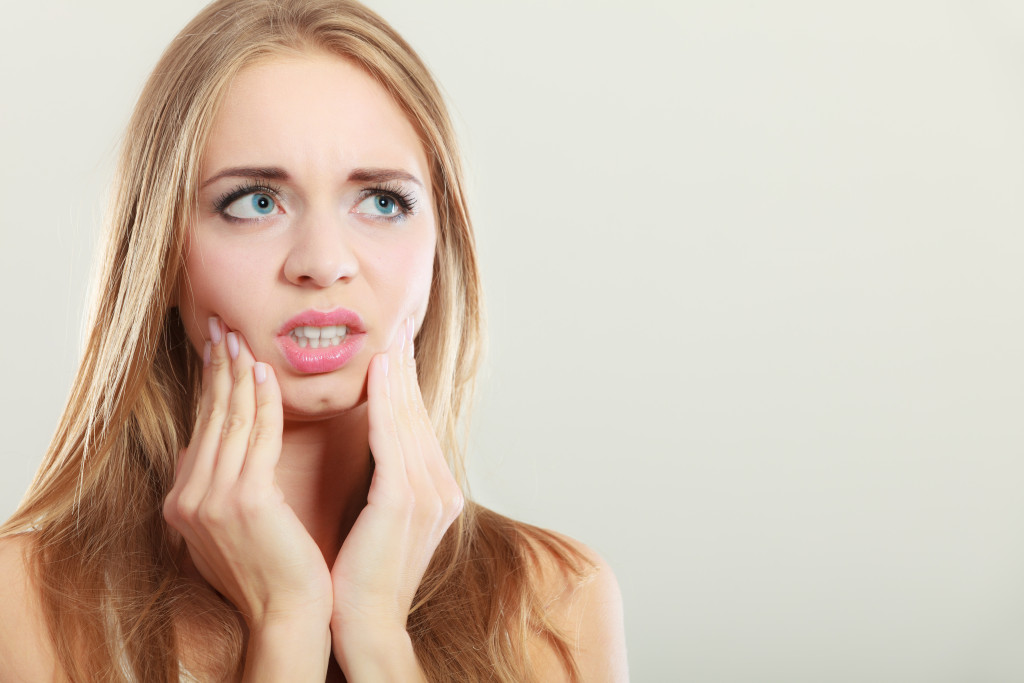 woman with tooth pain feeling anxious