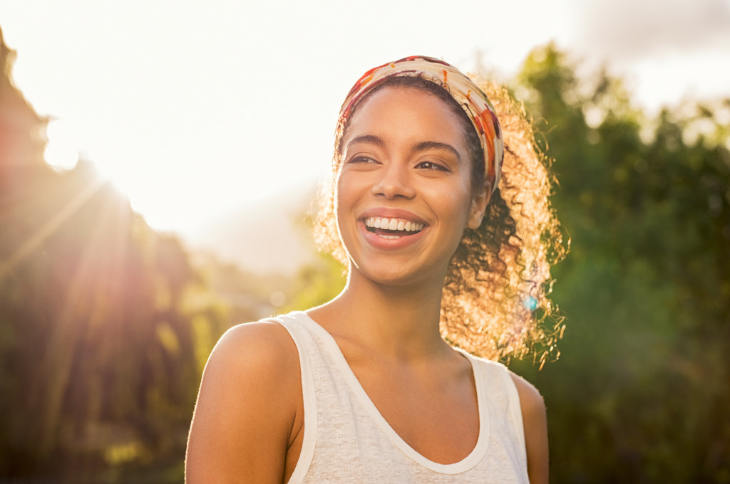 carefree young woman smiling under the sun