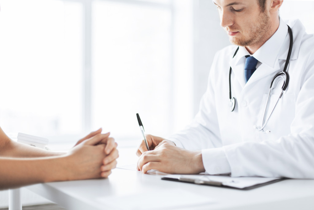 A male doctor writing a prescription for a patient