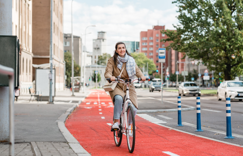 A woman biking in the city on a bike lane