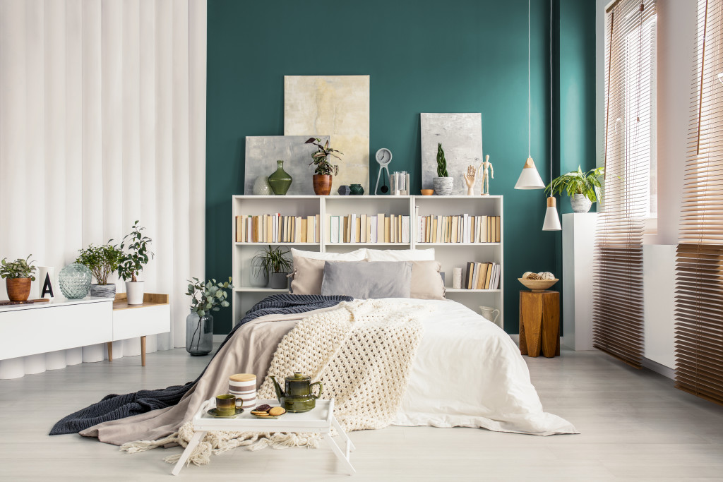 A headboard used as a bookcase in a bright, modern bedroom