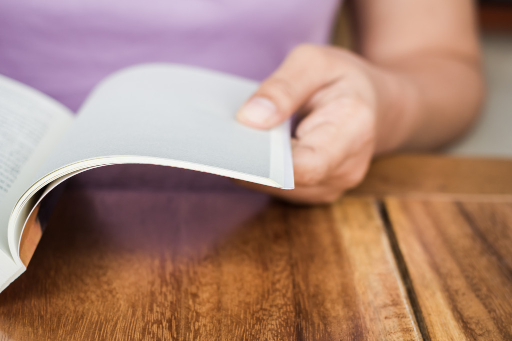 A person reading a book on a table