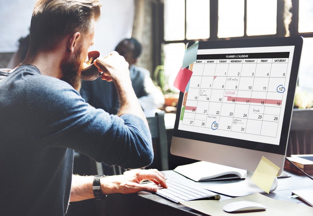 A man planning his schedule on a desktop calendar