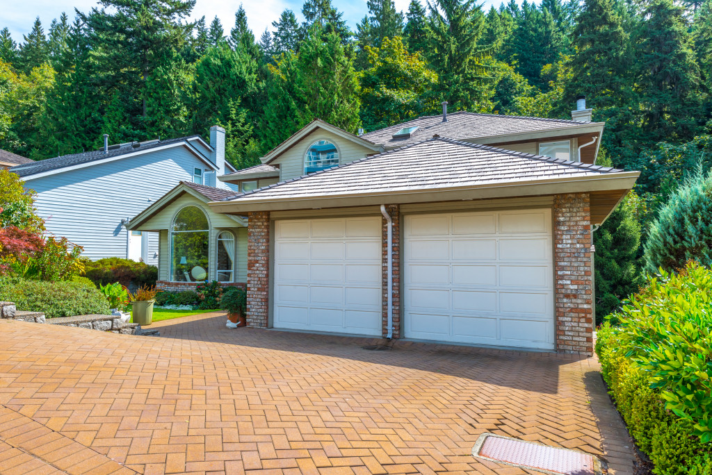 luxury home with paved driveway and well-maintained landscape