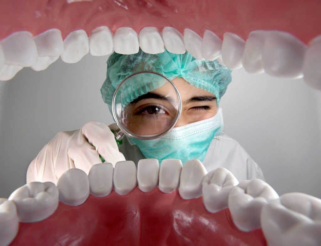 a dentist checking the patient's mouth