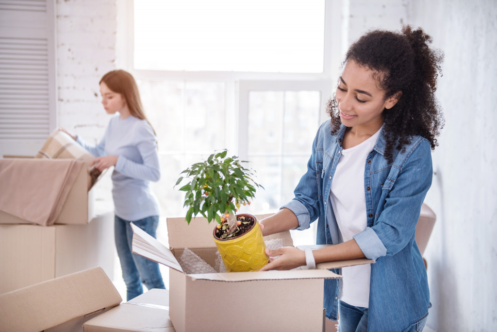 Two young women unpacking boxes in an apartment