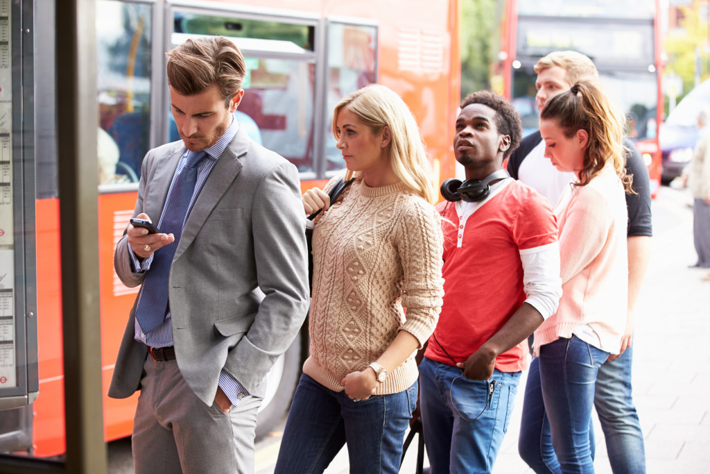 People queueing at a bus stop in the city.